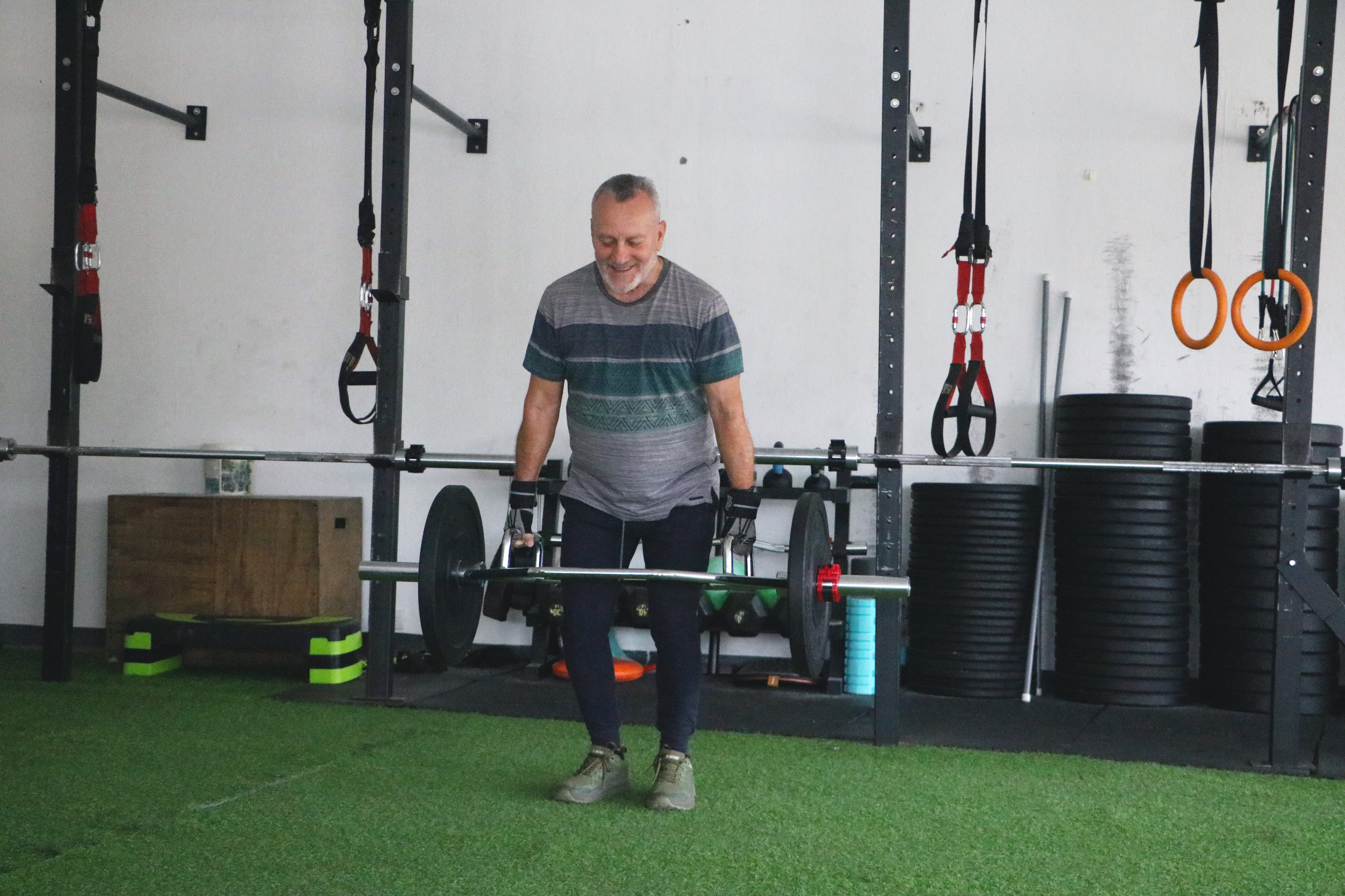 cliente adulto mayor realizando ejercicios de fuerza con equipos especializados