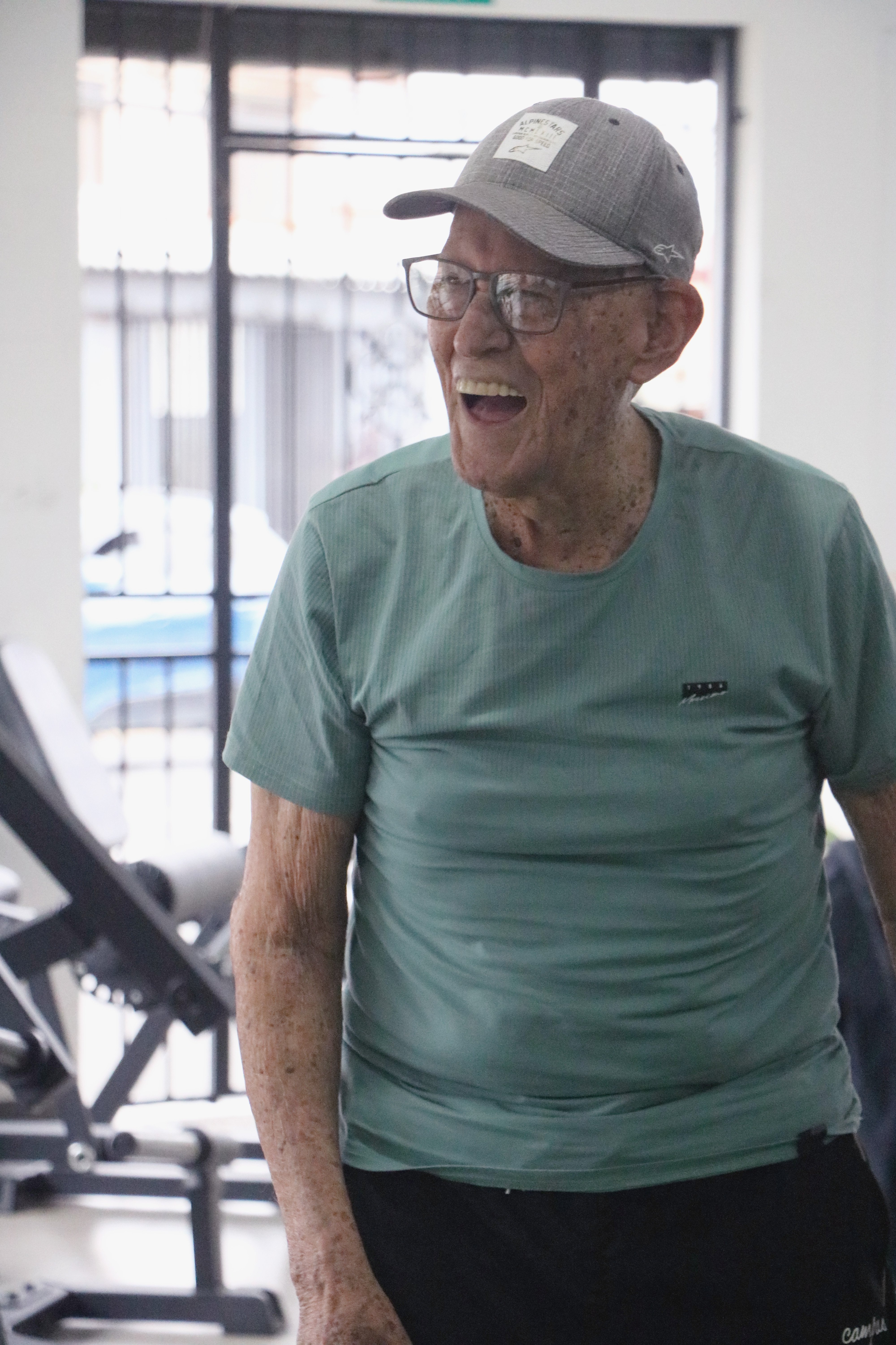 cliente adulto mayor sonriendo con alegría durante su sesión de ejercicio